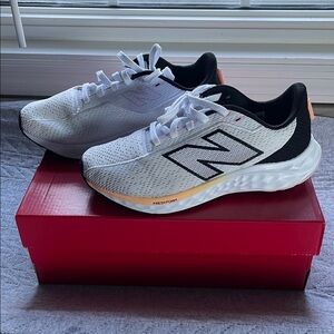 New Balance White and Black Sneakers with Orange Accents.